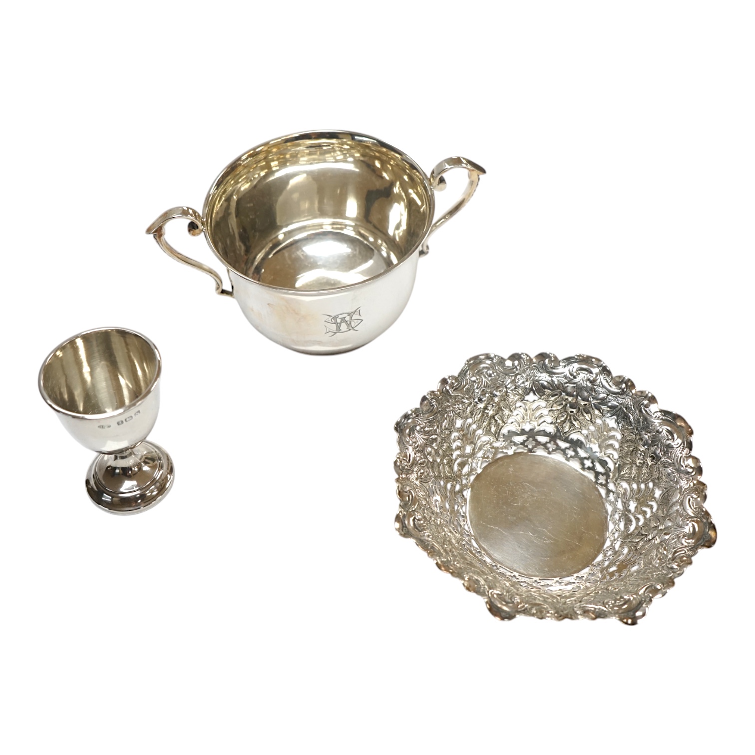 An Edwardian silver porringer, London, 1904, height 72mm, together with a pierced silver bonbon dish and an egg cup, 6.4oz. Condition - fair to good